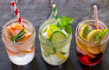three glasses with drinks made of water and fruits